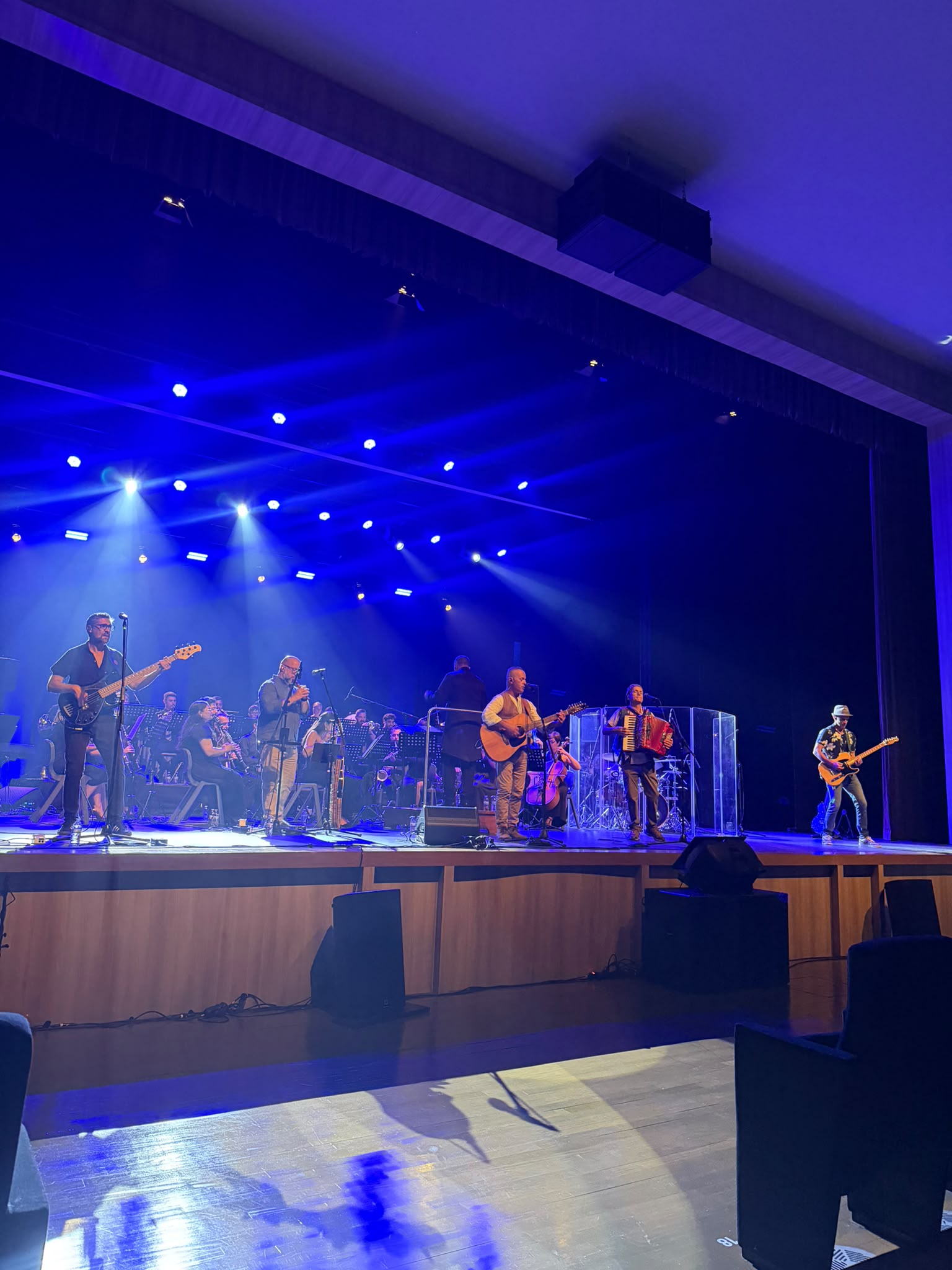 O encontro em palco sob a iluminação azul.